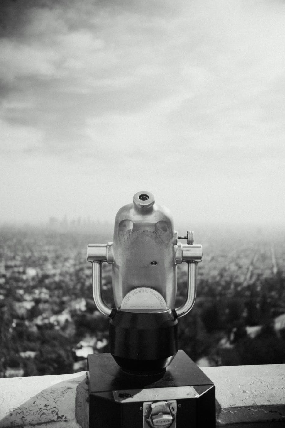 black and white of a coin operated telescope overlooking a great expanse