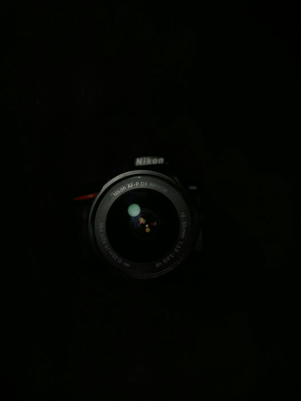 A black Nikon camera in darkness