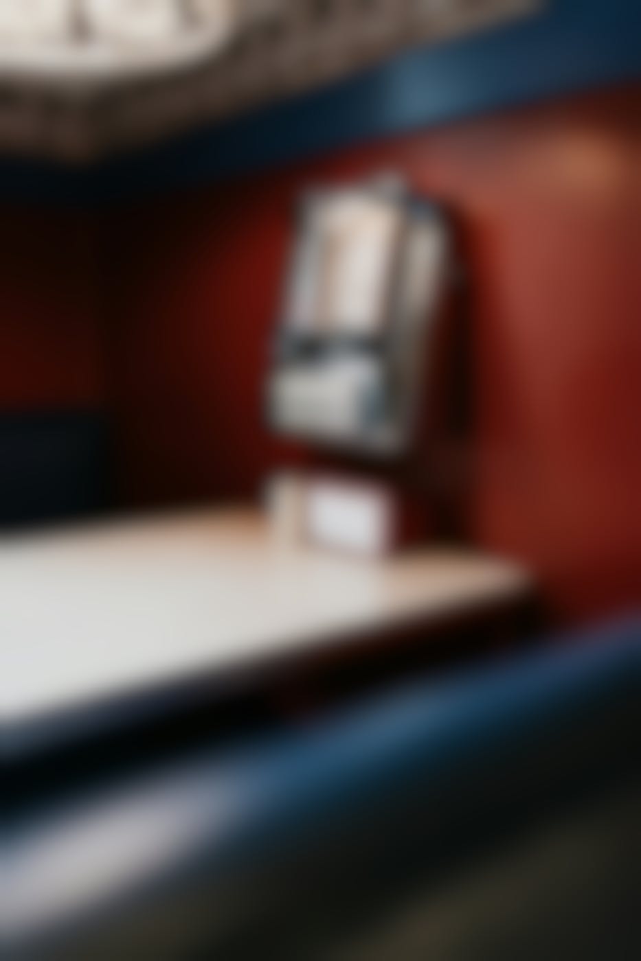 A classic diner booth with a wall mounted juke box