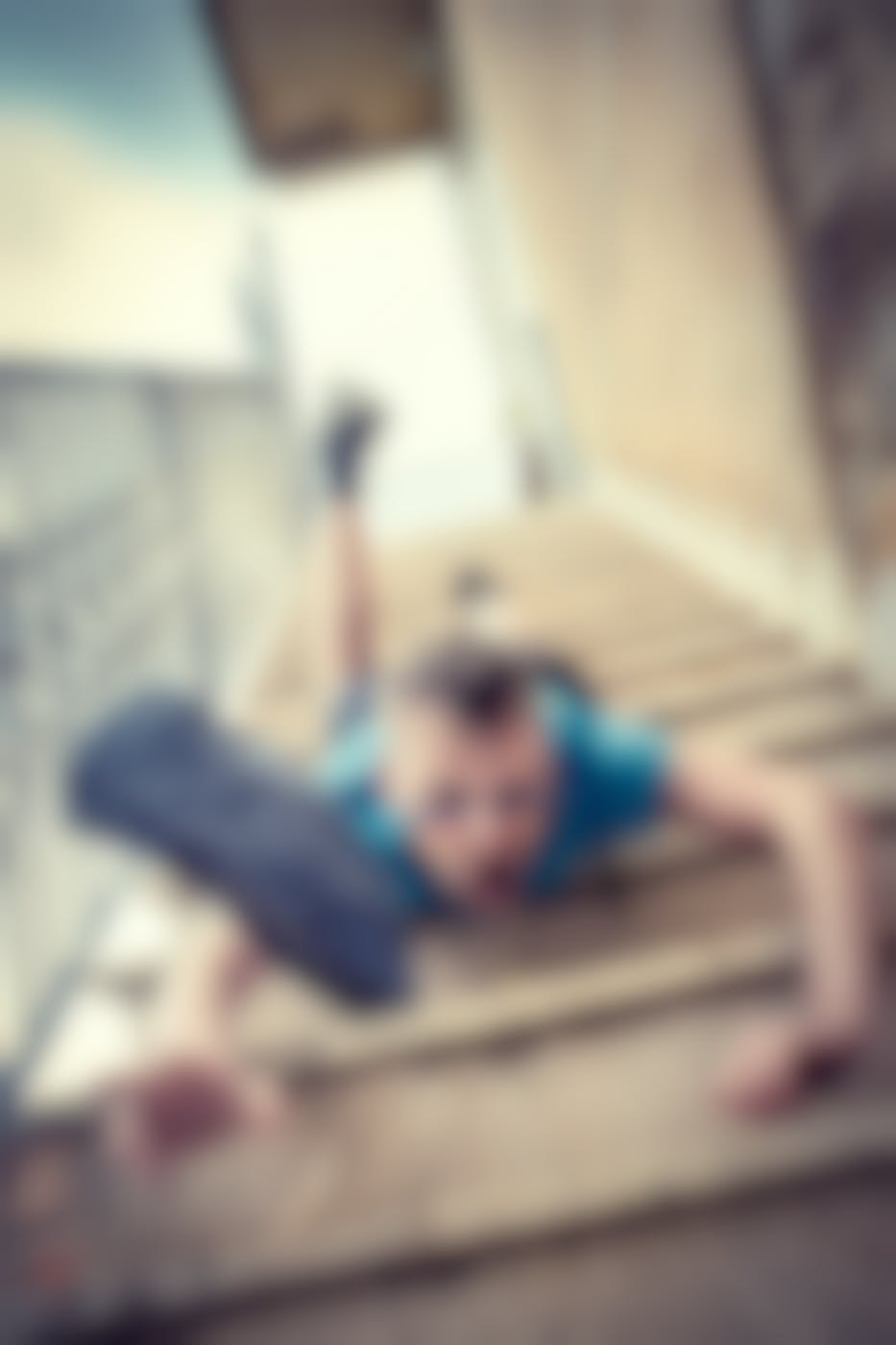 A man falling headfirst down a flight of concrete stairs