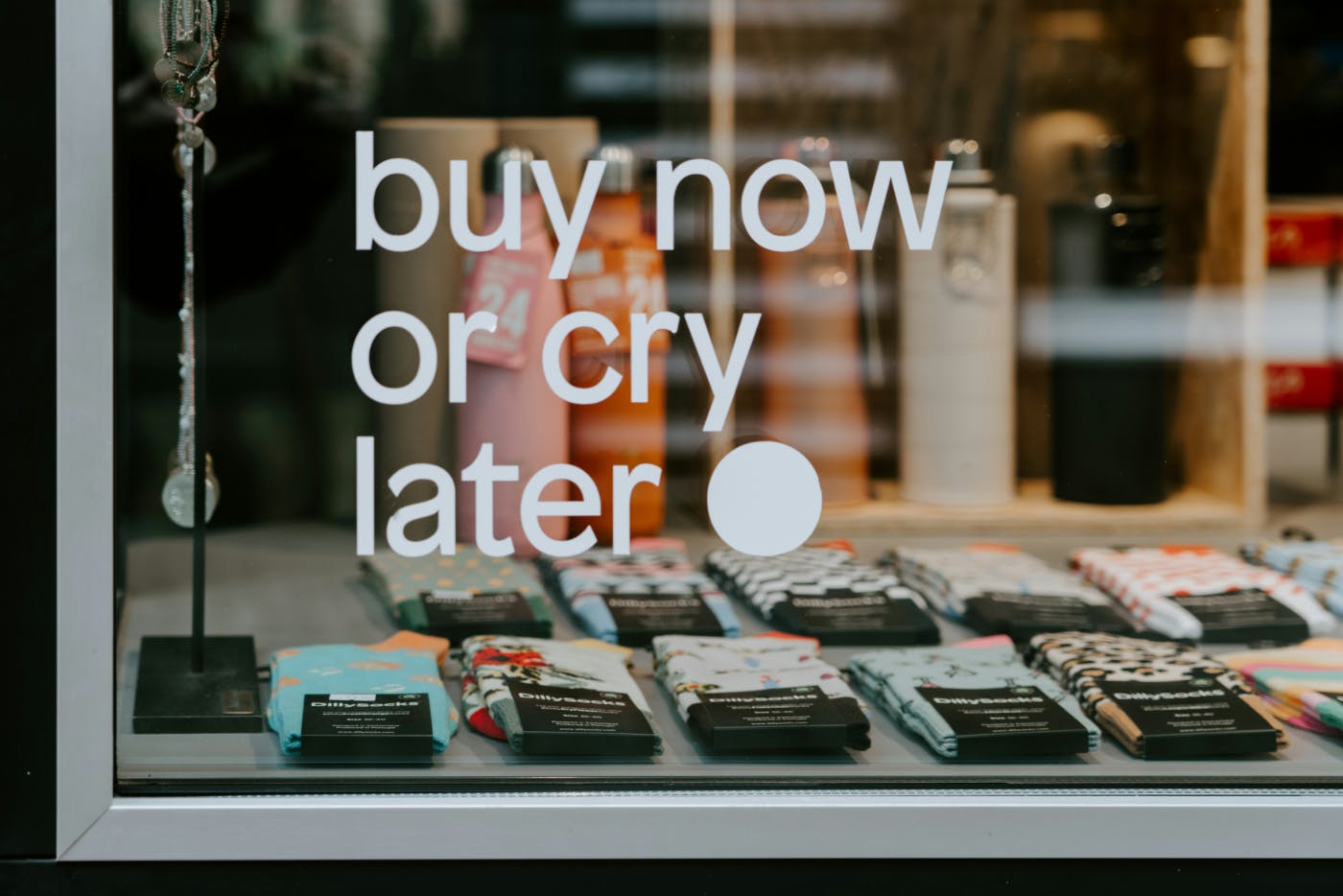 Words on a shop window reading By Now Or Cry Later