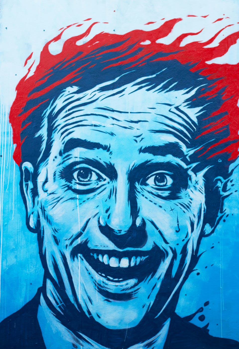 A saturated blue portrait of a man with burning hair
