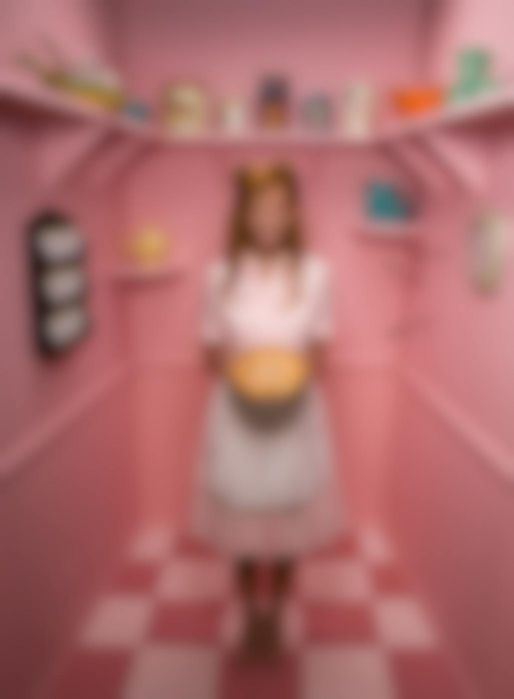 A "tradwife" holding a pie in a pink pantry