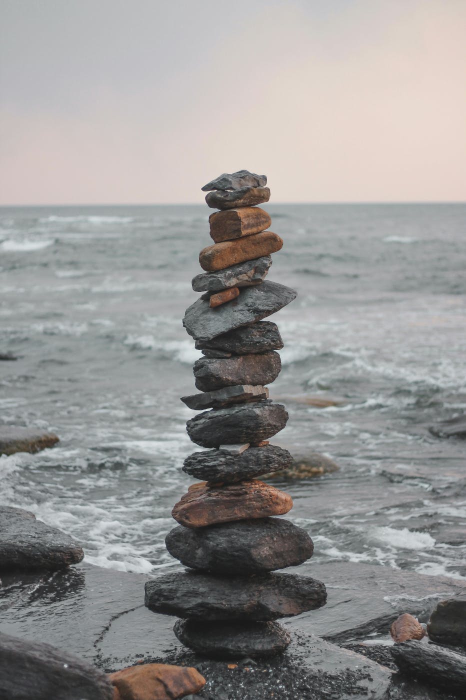 A tall cairn on a rock by the sea