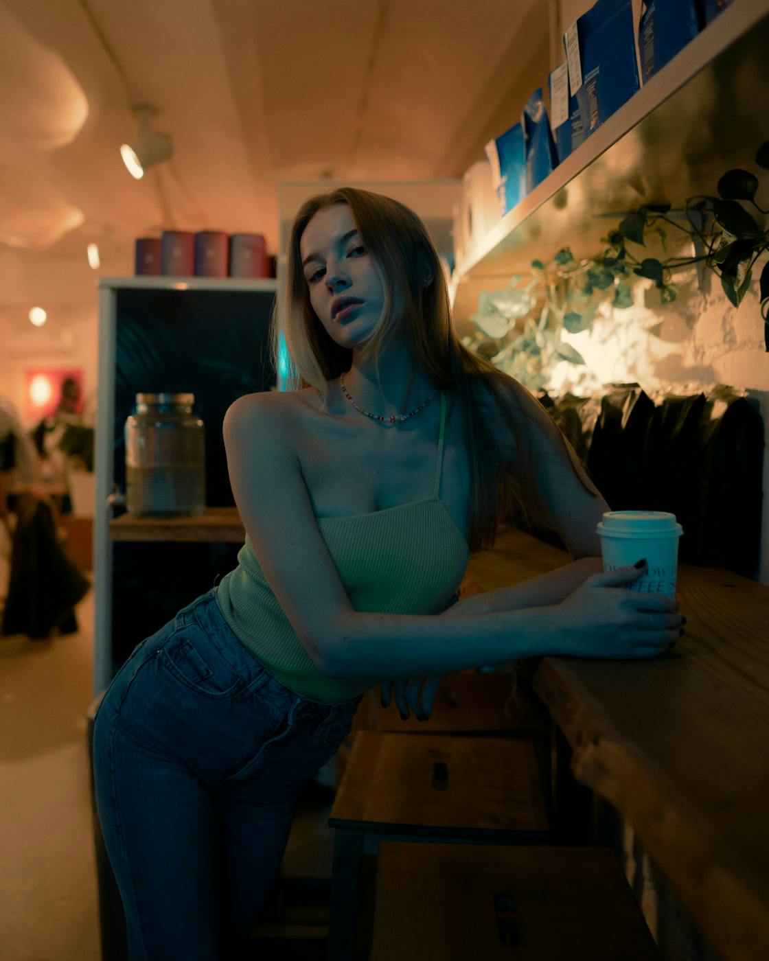 A lovely woman leaning on a counter in a coffee shop