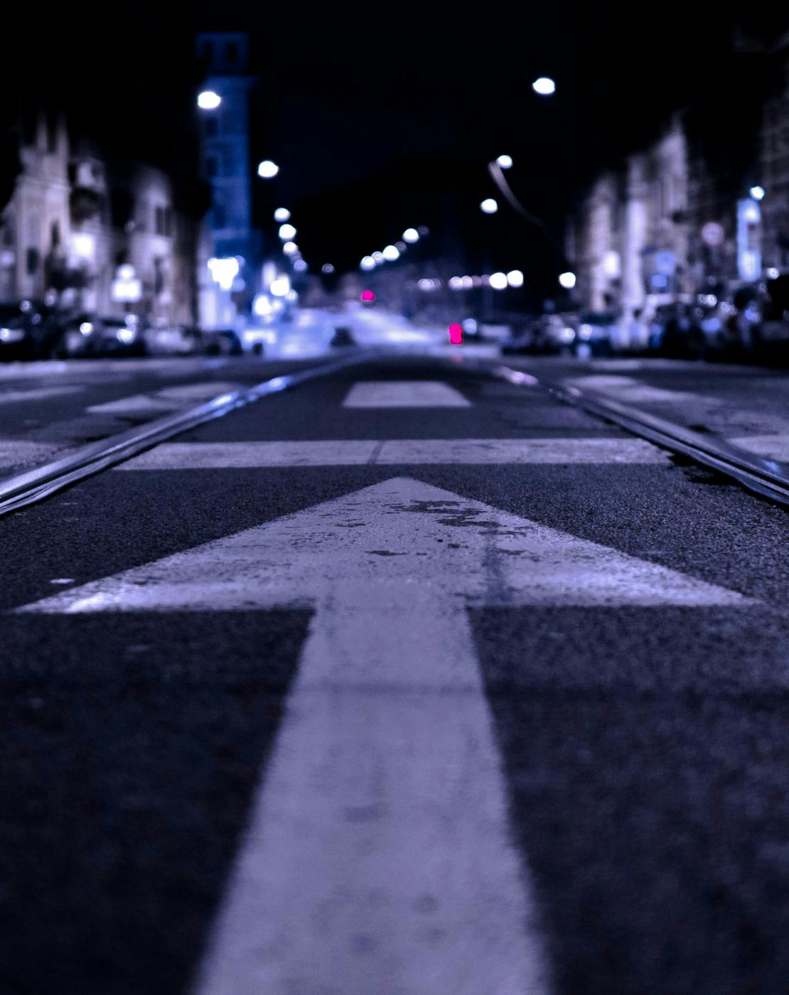 A shallow focus shot of a street with a forward arrow in focus