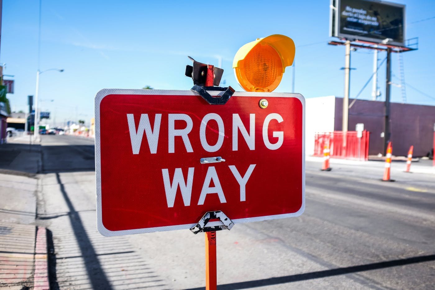 A red wrong way sign on a street