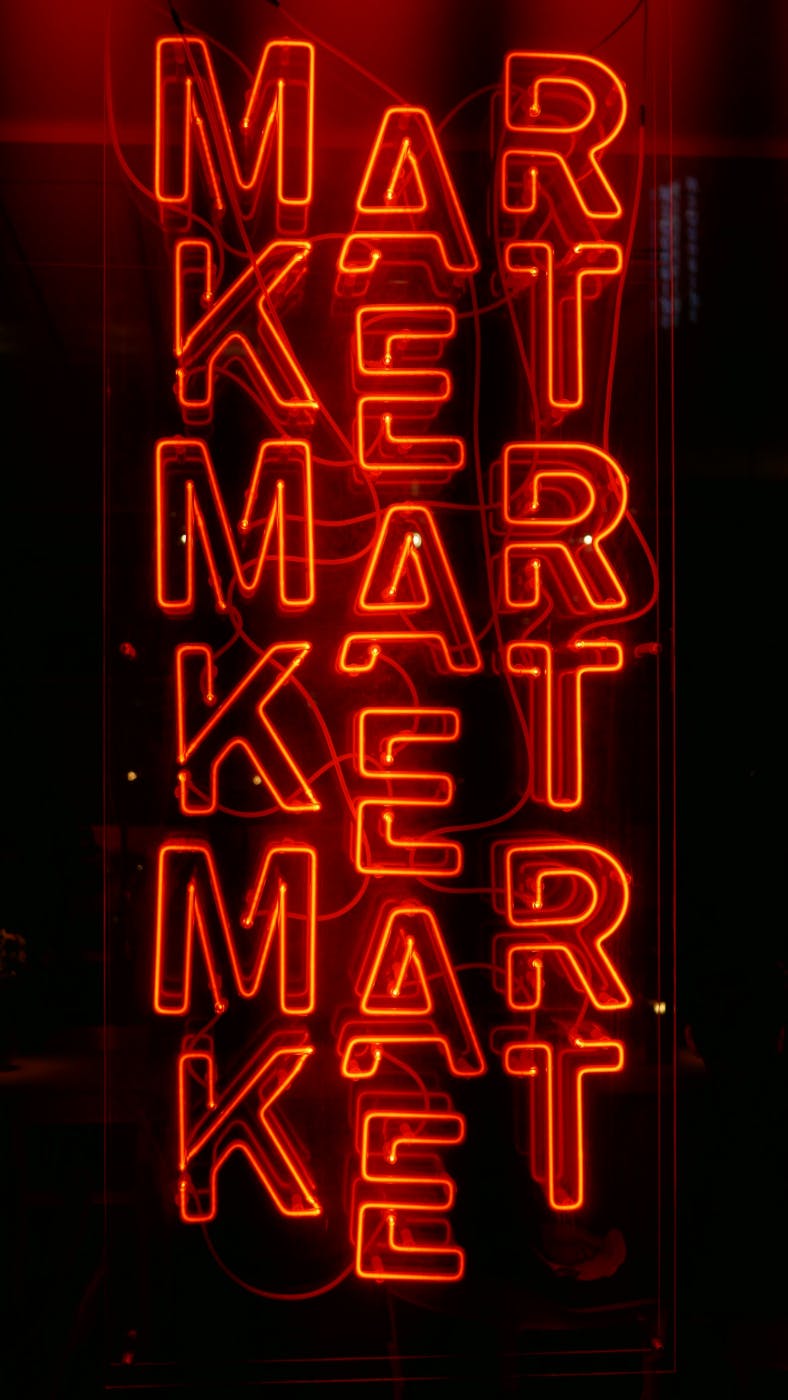 A vertical red neon market sign