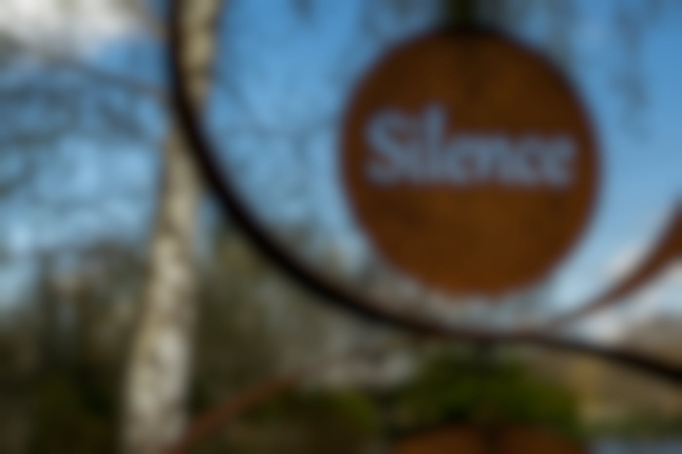 A rusted metal sign with the word Silence cut out of it