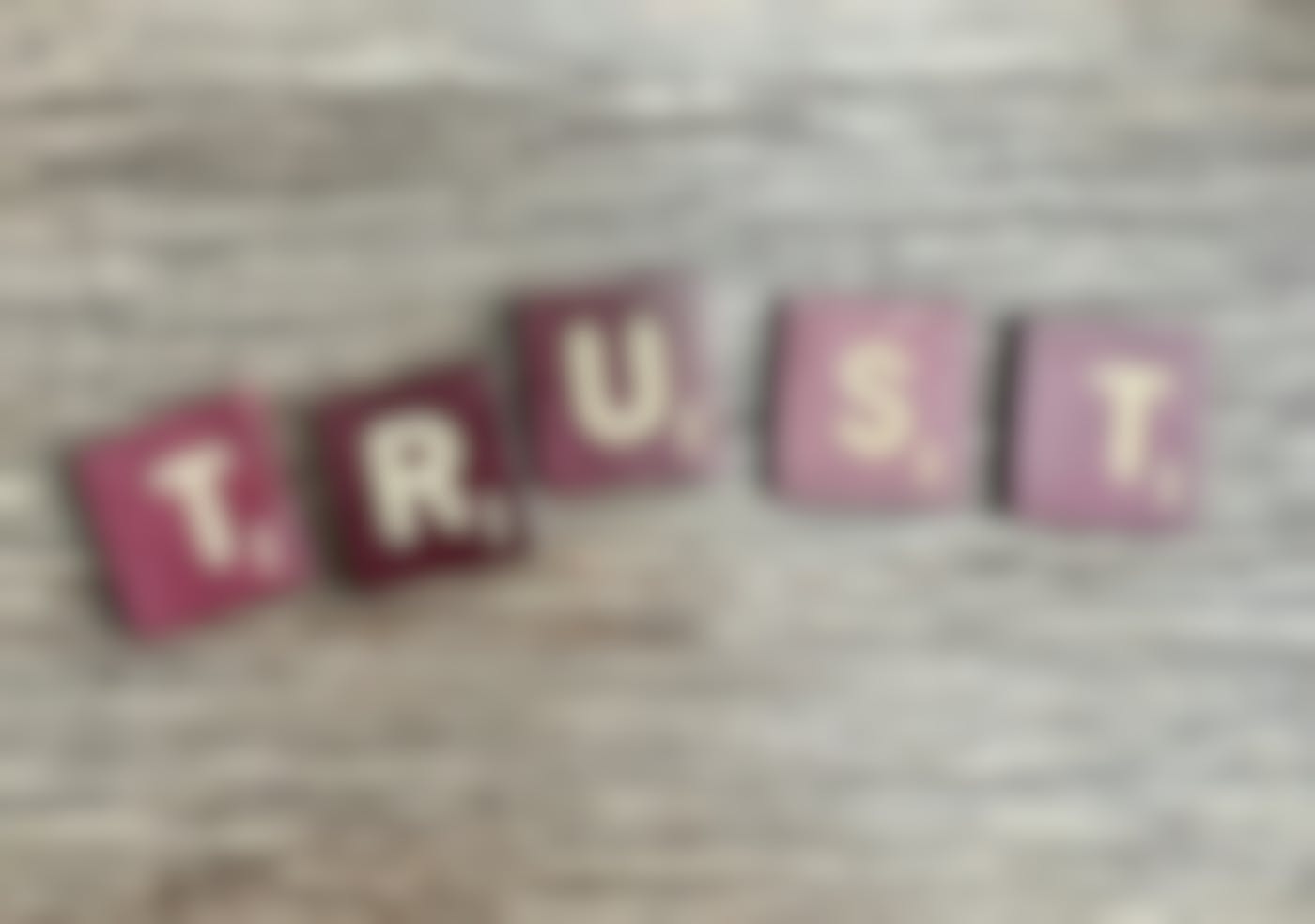 Scrabble tiles spelling out TRUST