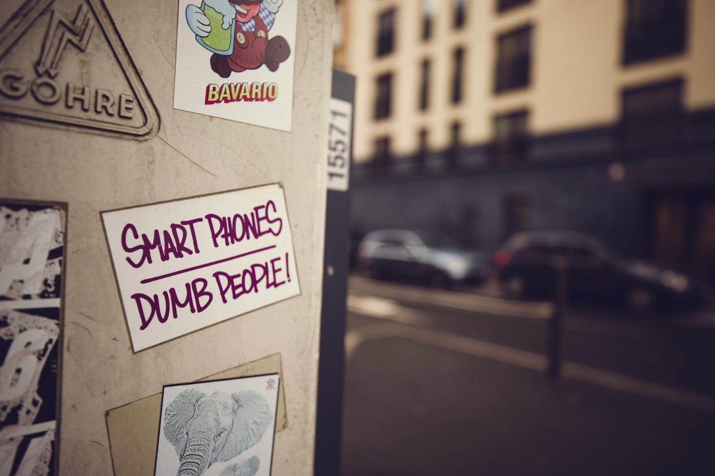 A poster on a wall reading: Smart Phones. Dumb People.