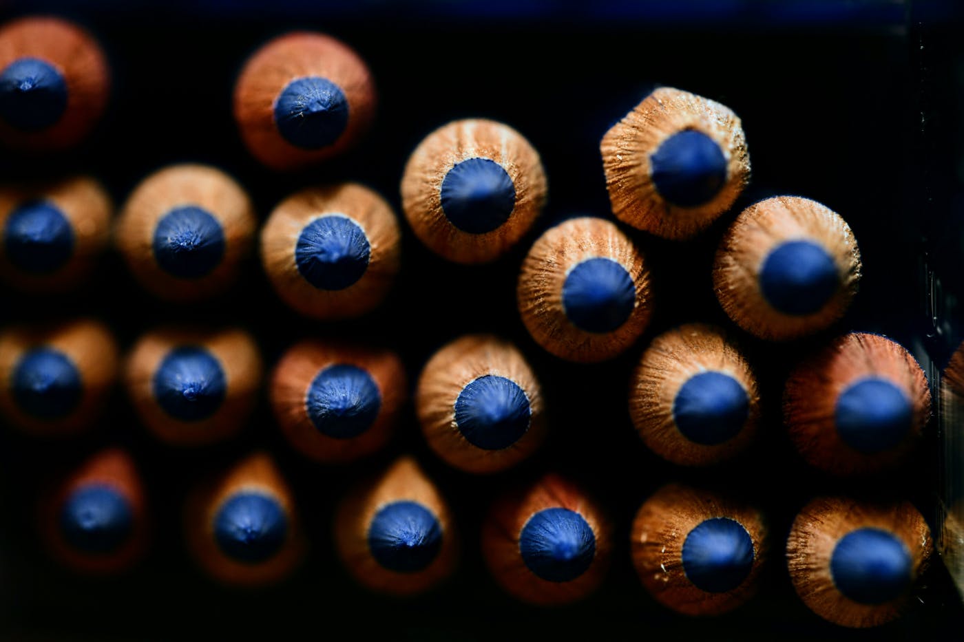 Many blue pencils their tips facing camera