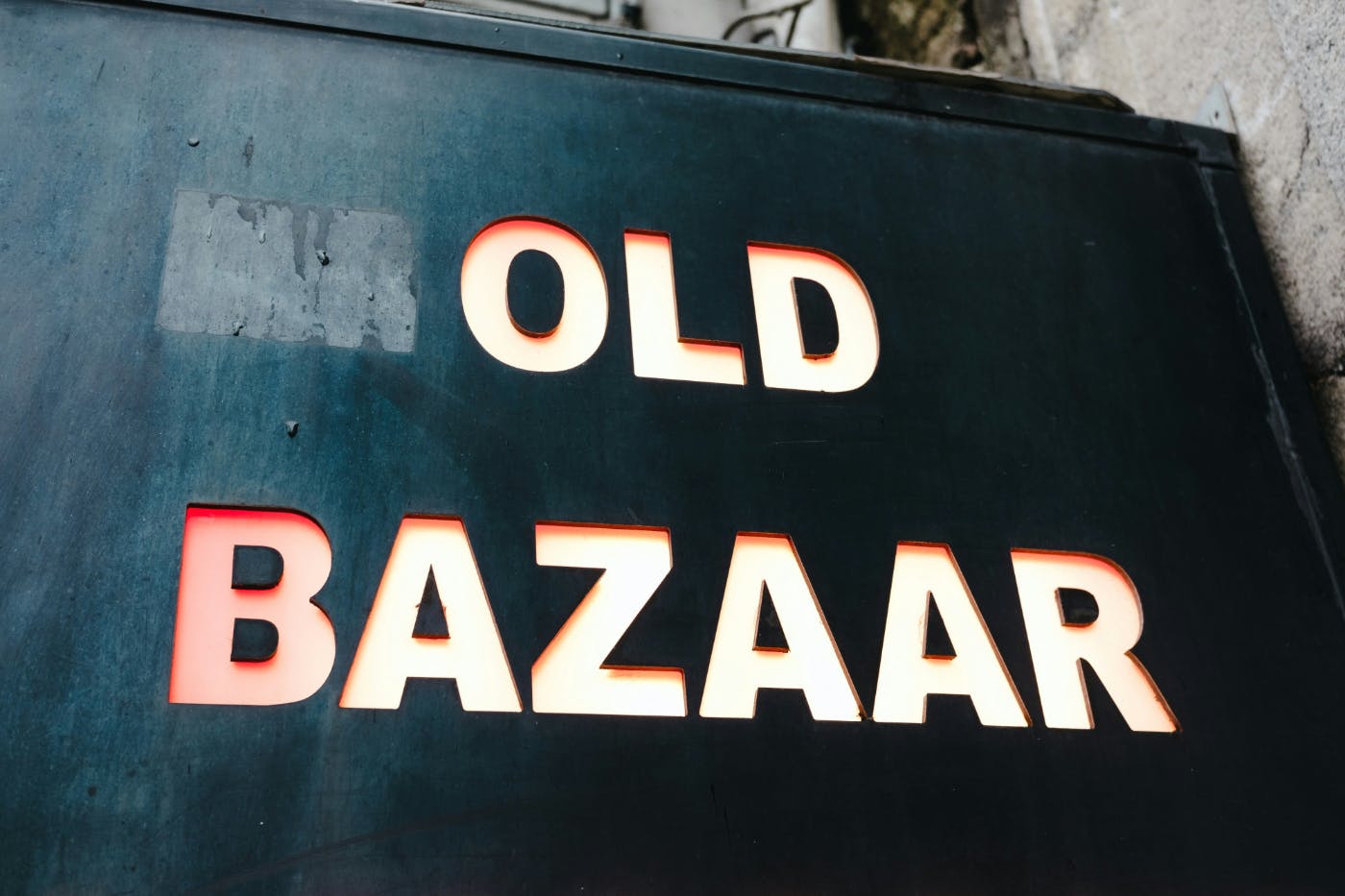 A sign on the side of a building reading Old Bazaar