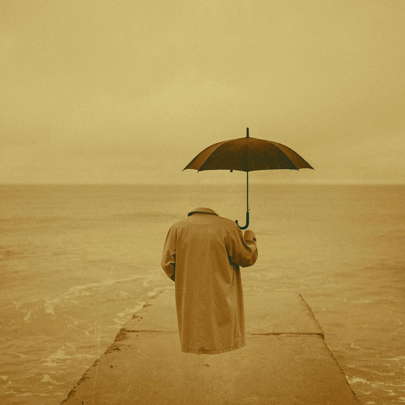 An empty raincoat and open umbrella floating as if occupied at the end of a stone pier