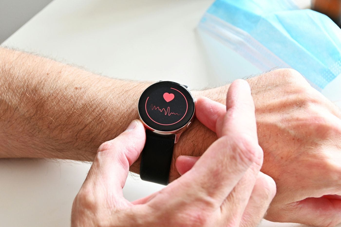 A person checking their pulse on a smartwatch