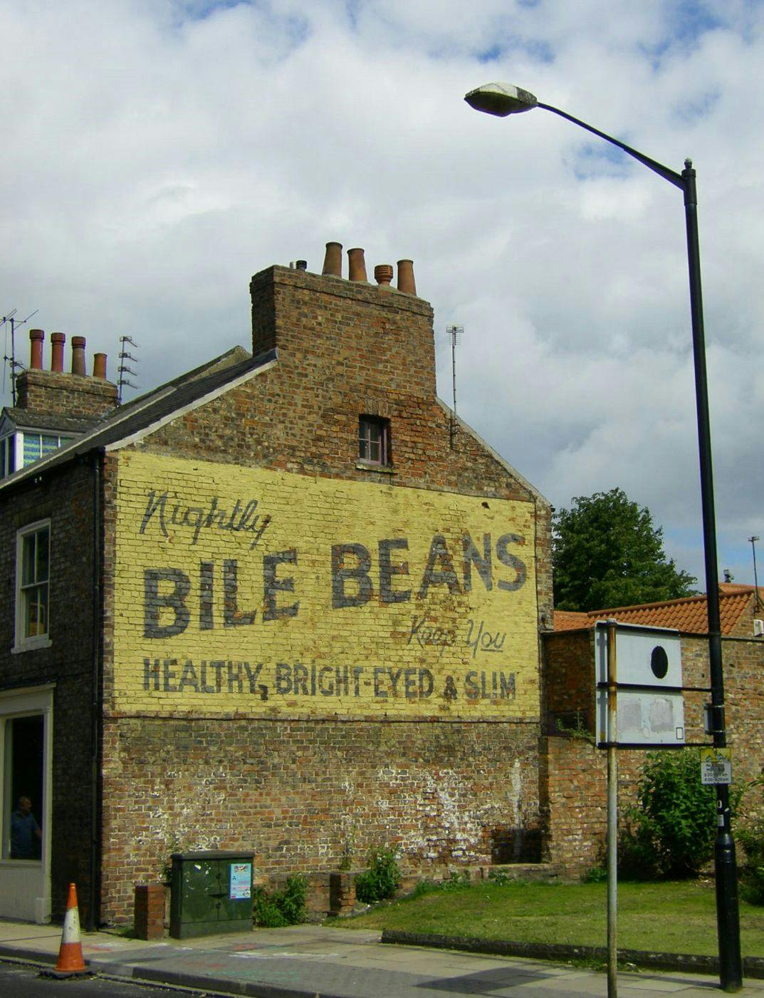 an ad on the side of a brick building for Bile Beans