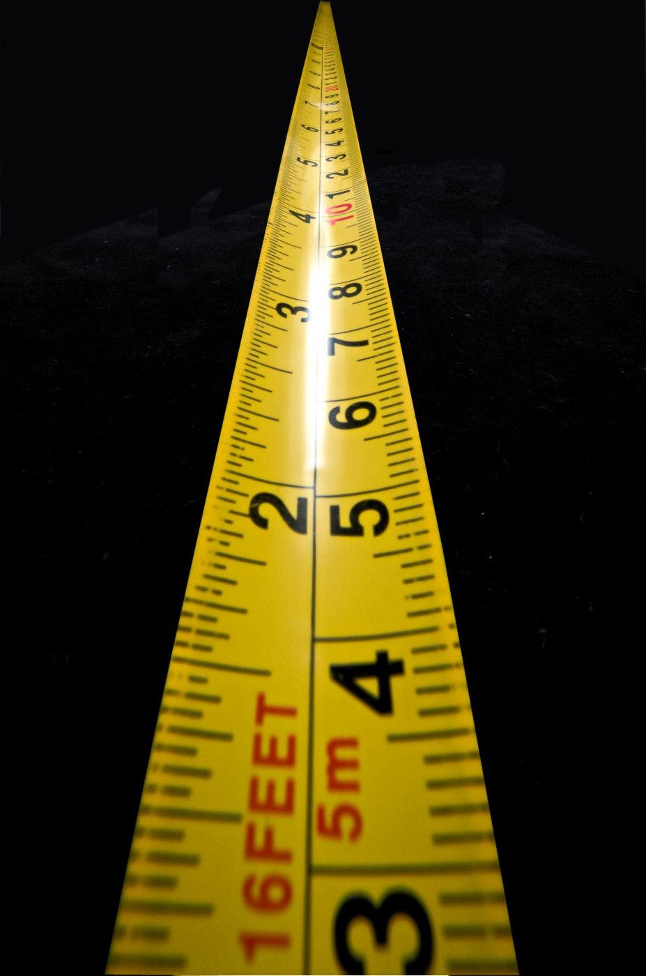 a low angle shot of a yellow measuring tape