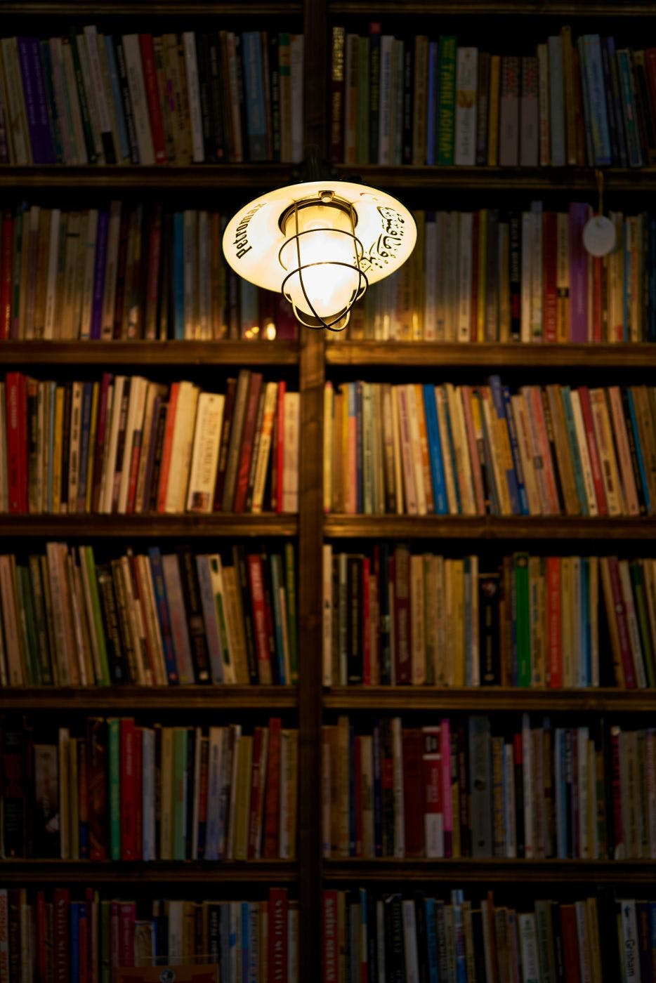 Shelves of old books and an overhead light bulb