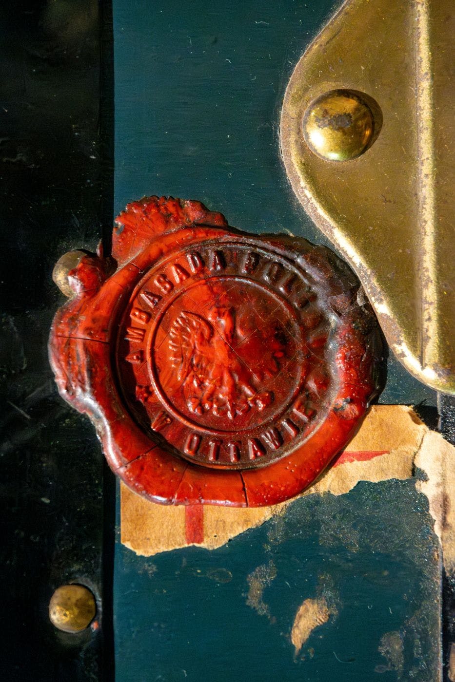 A red wax seal on a door handle