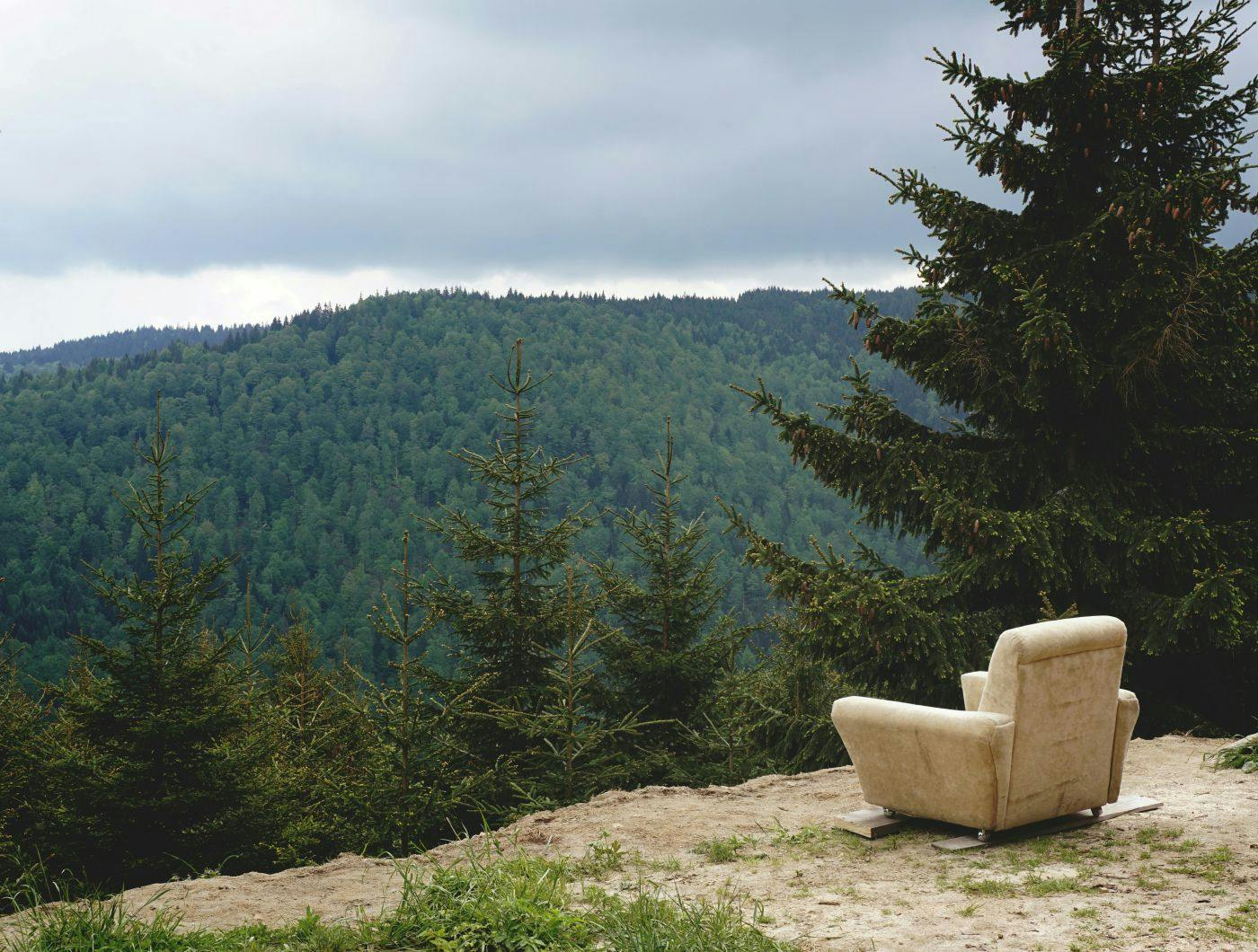 An easy chair on a the edge of a cliff overlooking a beautiful valley