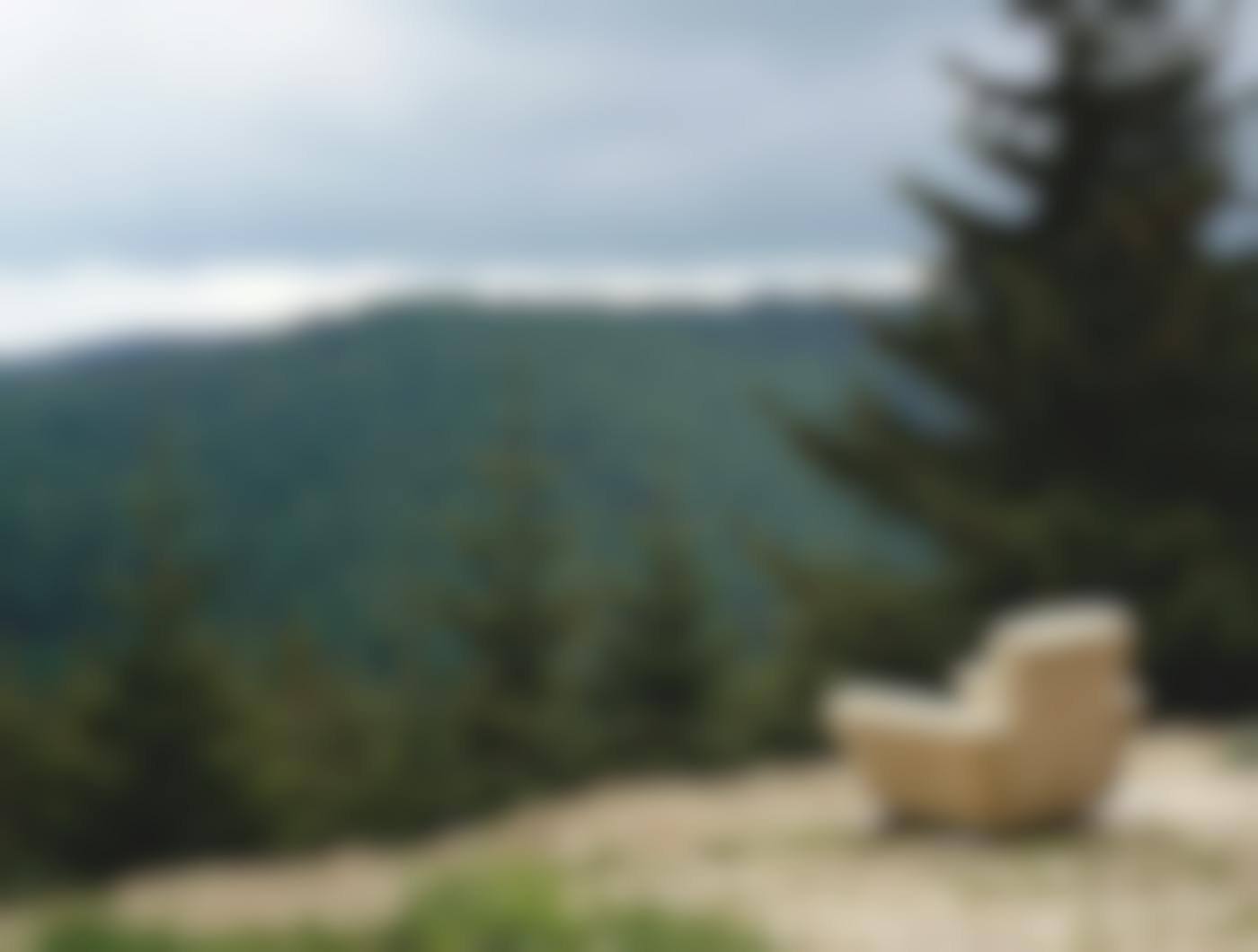 An easy chair on a the edge of a cliff overlooking a beautiful valley