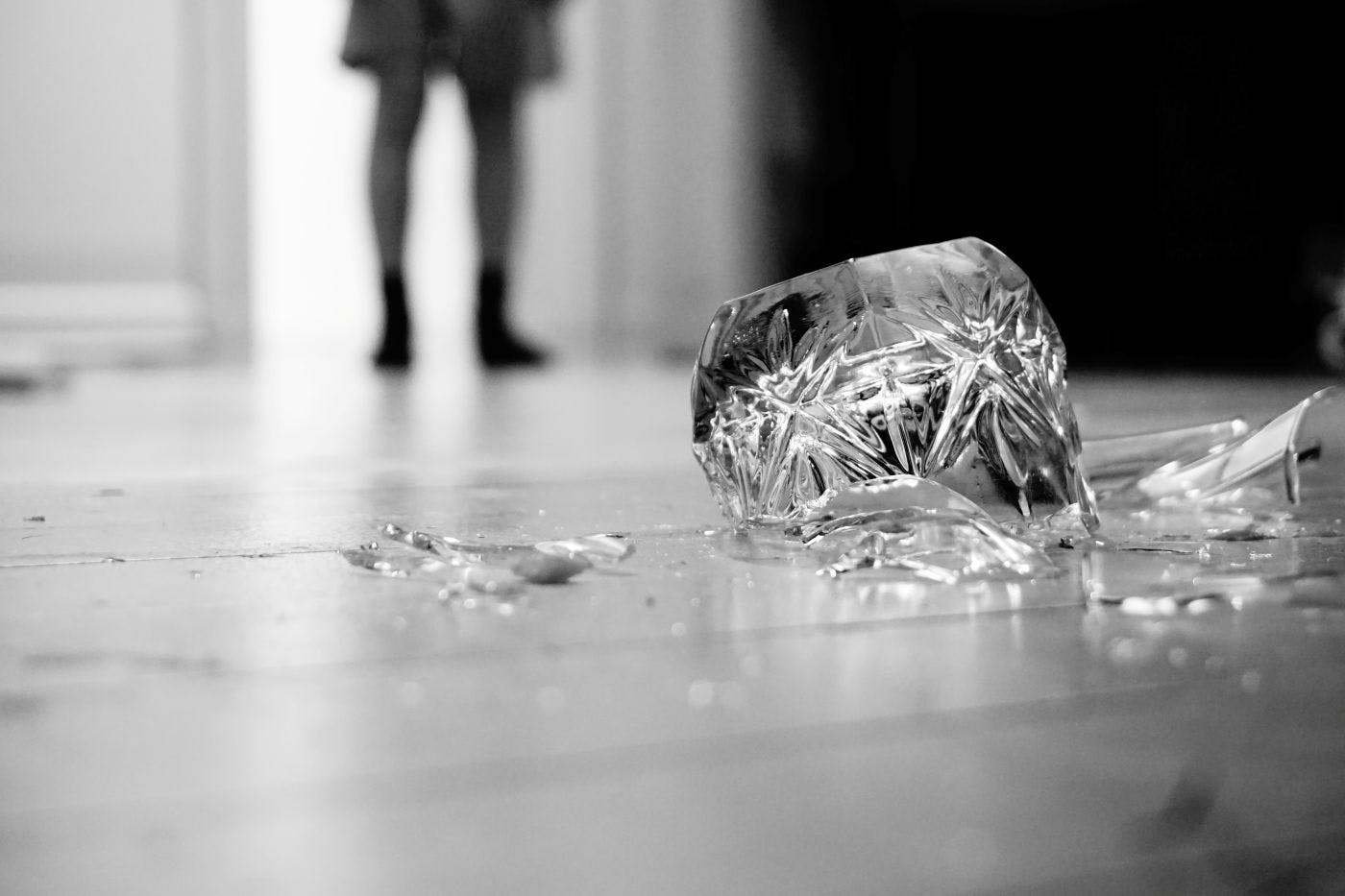 Black and white of a shattered crystal glass on a floor