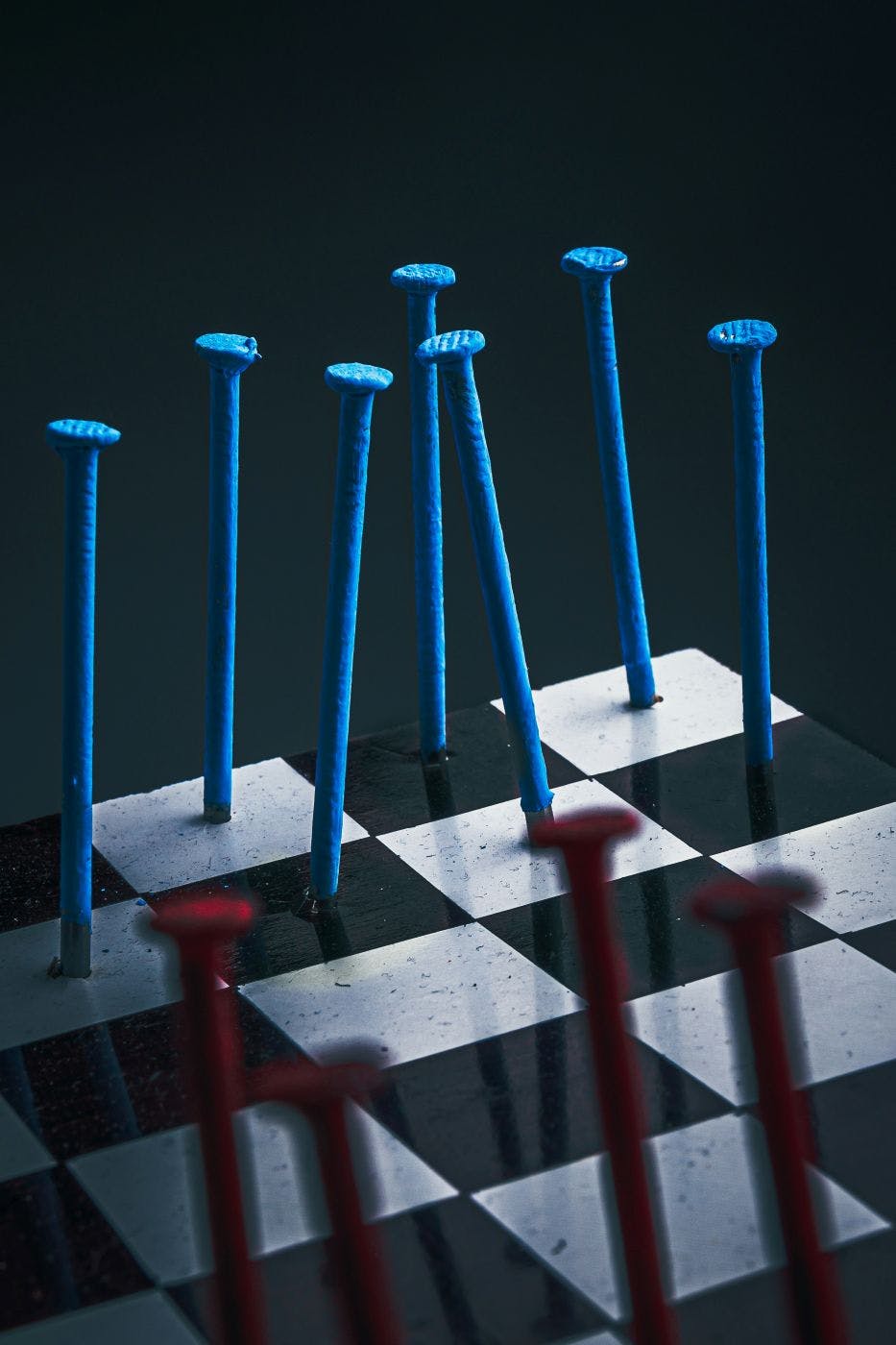 A chess board with blue and red nails as pieces