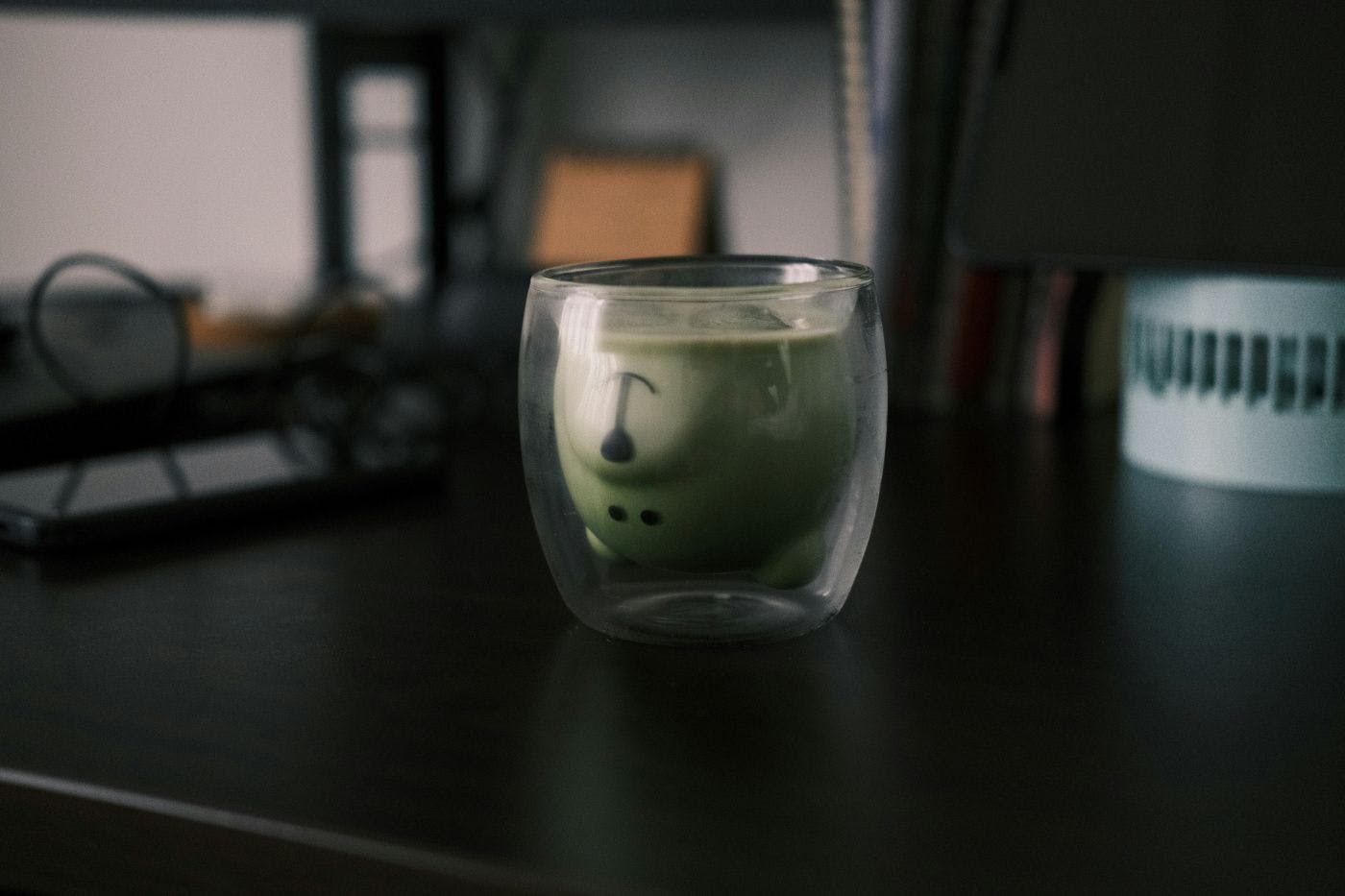 A cartoon bear head upside down in a glass of water