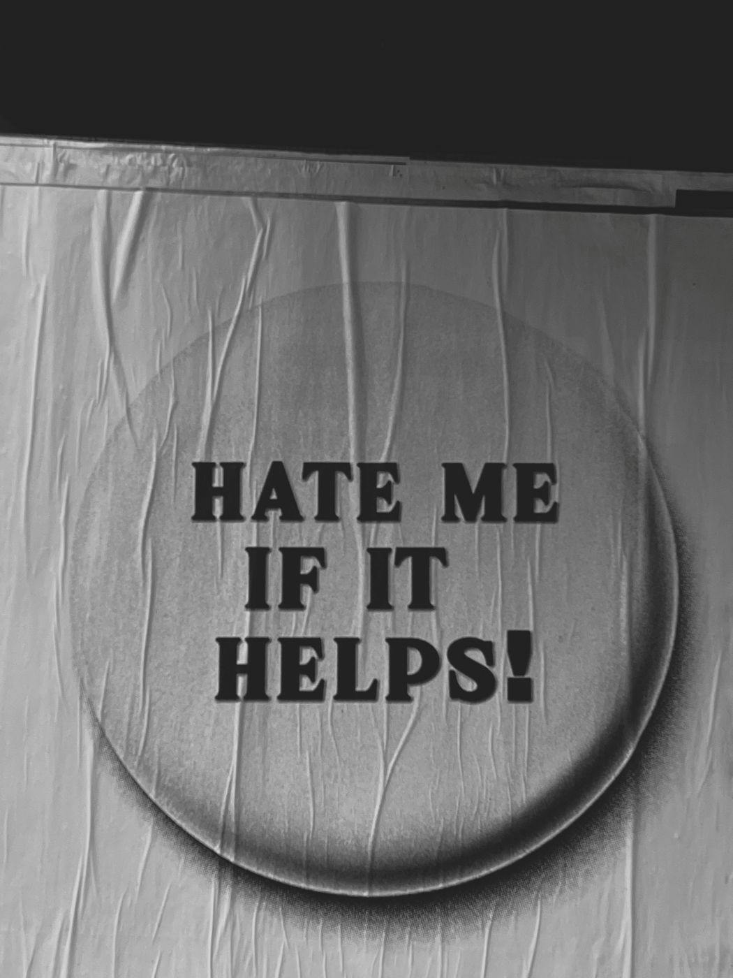 Wrinkled poster that reads HATE ME IF IT HELPS