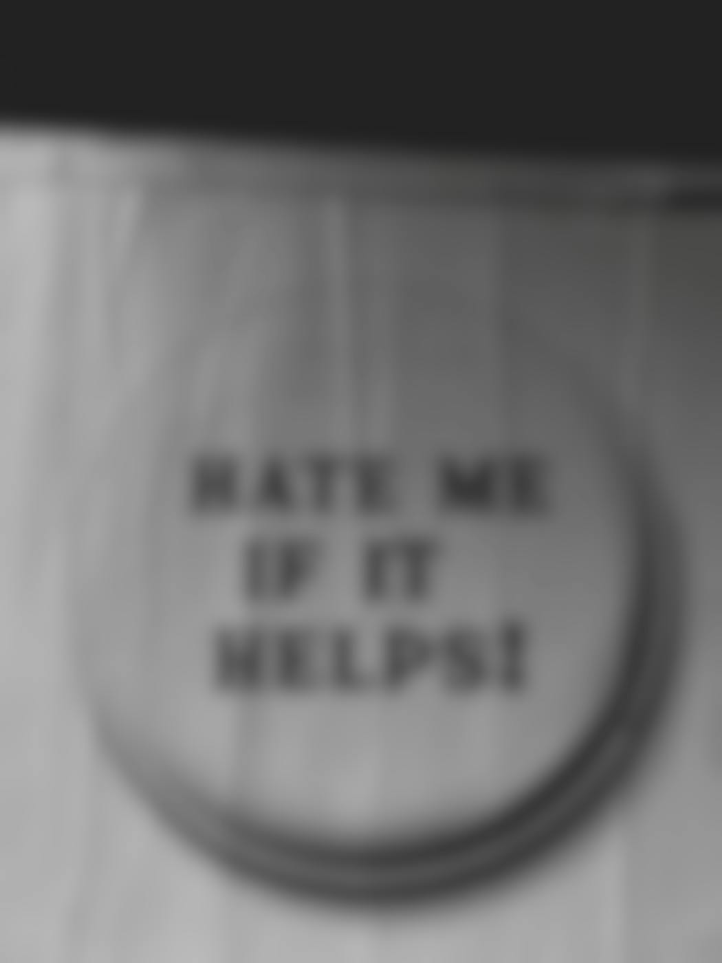 Wrinkled poster that reads HATE ME IF IT HELPS
