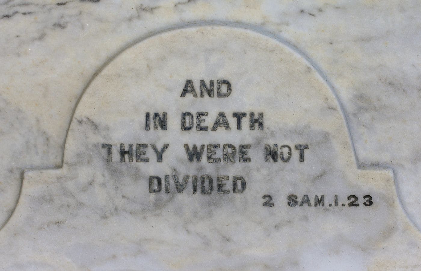 A marble headstone with the inscription "And in death they were not divided"