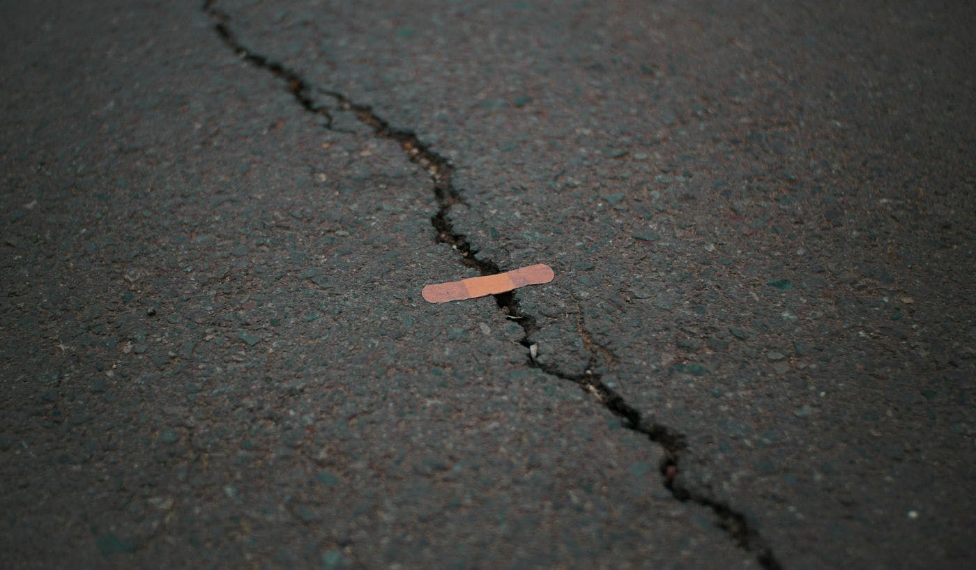 A crack in asphalt "fixed" with a band aid