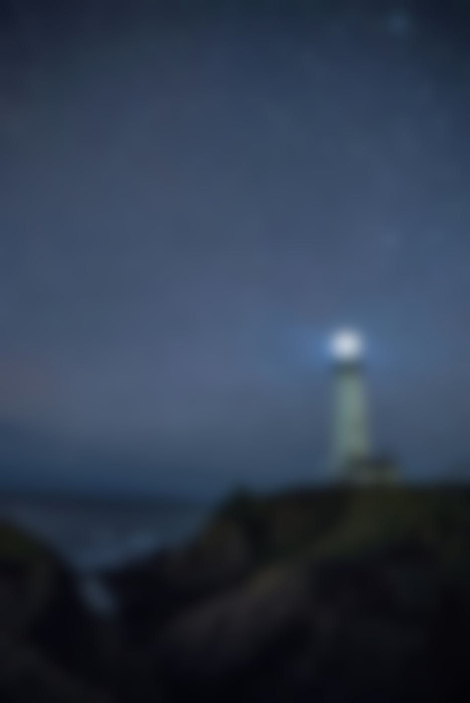 A lighthouse under a star filled sky