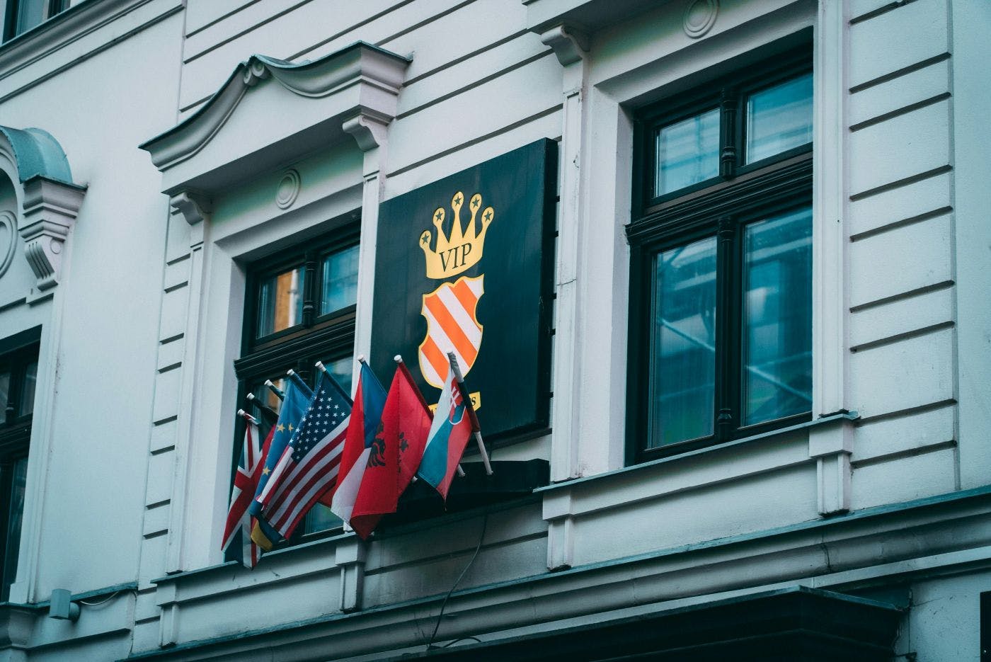 Flags of many nations under a VIP crown on a building