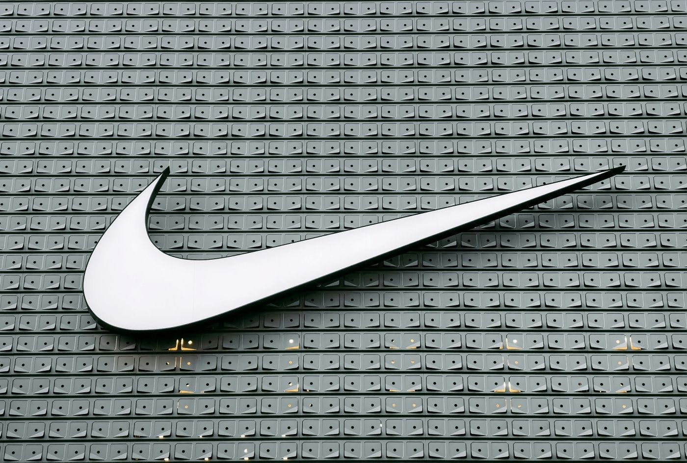 A giant white Nike swoosh on a gray building