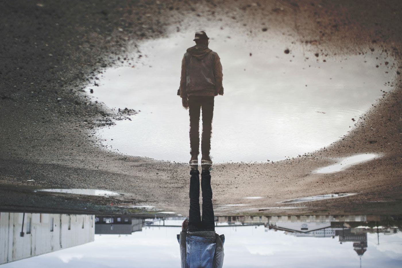 Upside down image of the reflection of a man in a puddle