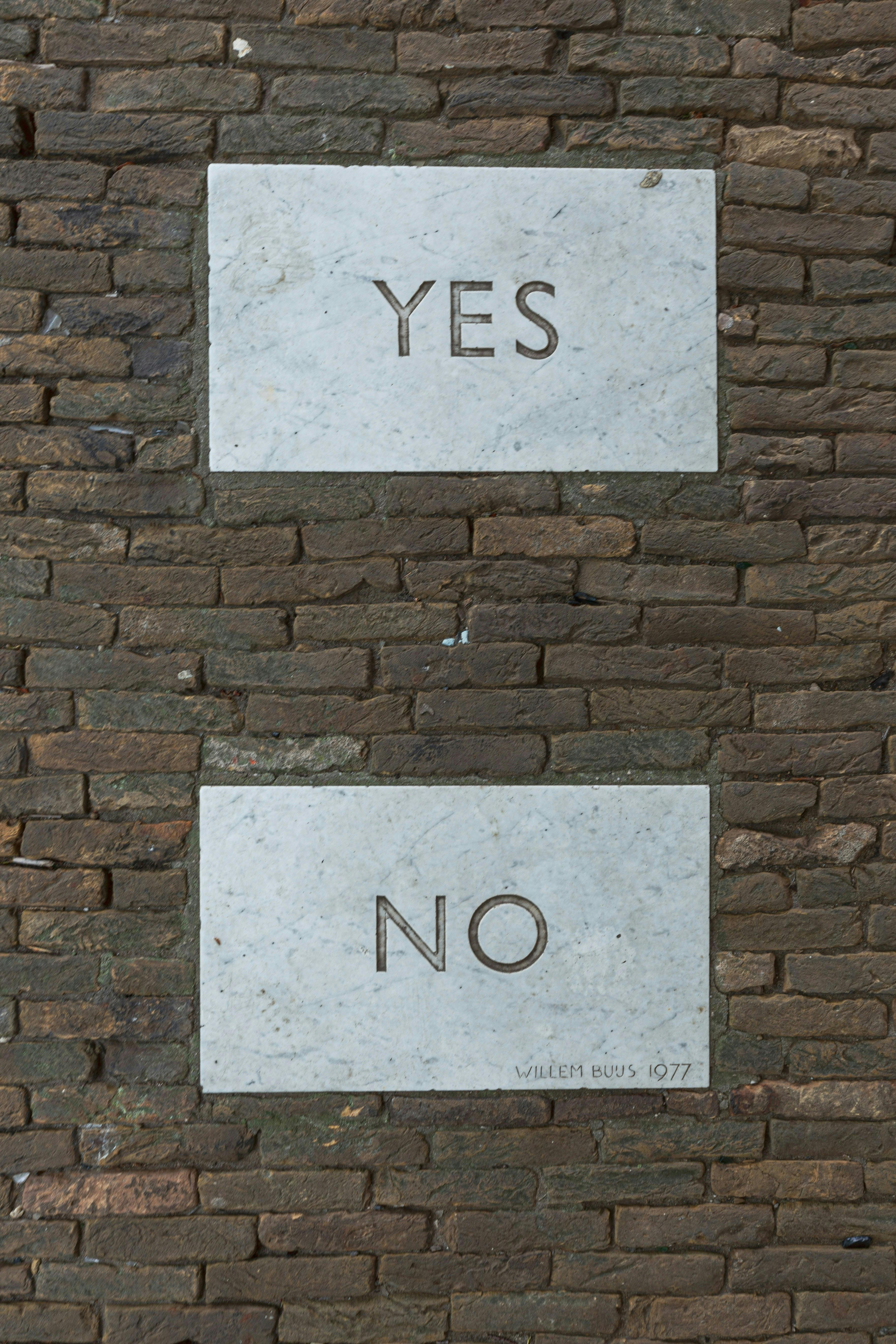 Two marble blocks in a brick wall, top: yes, bottom: no