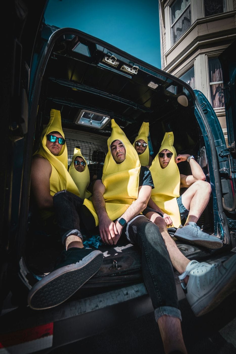 Five guys dressed as bananas in the back of a van