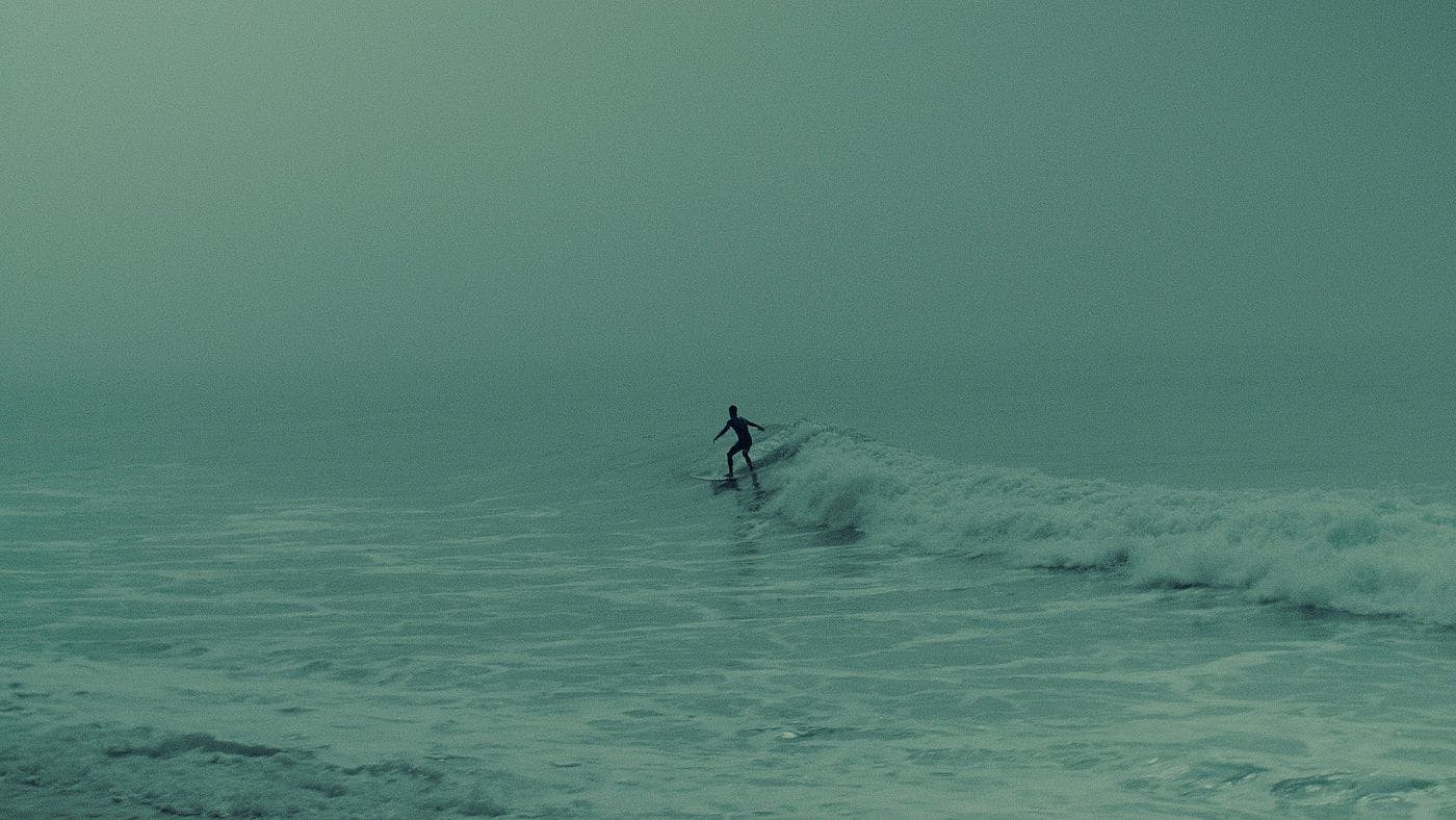 A man surfing in the fog