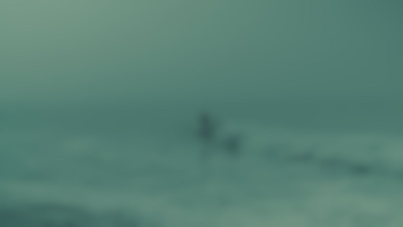 A man surfing in the fog