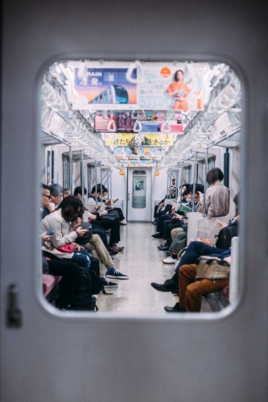 People on a subway car looking at their phones