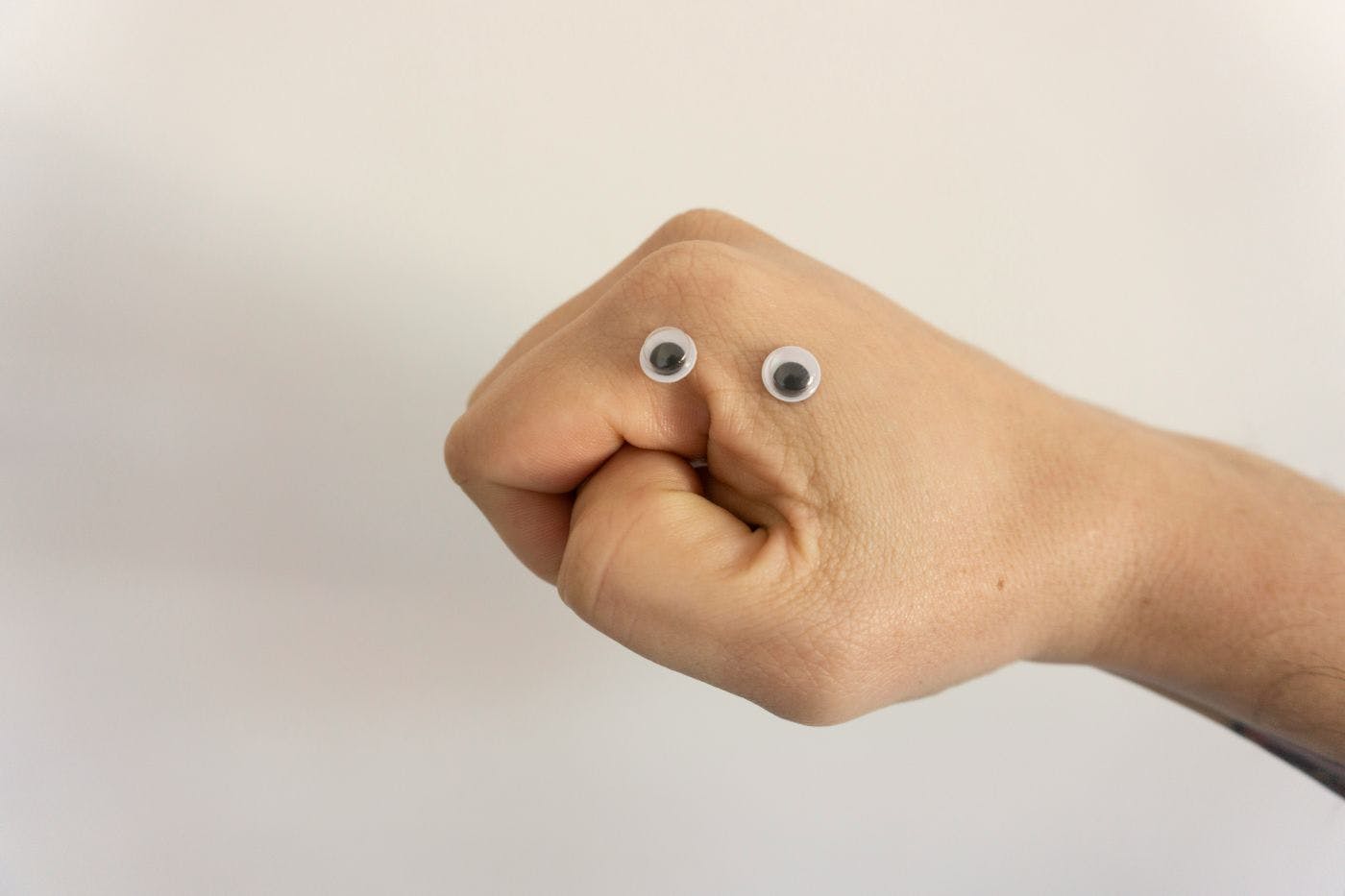 A fisted hand with googlie eyes