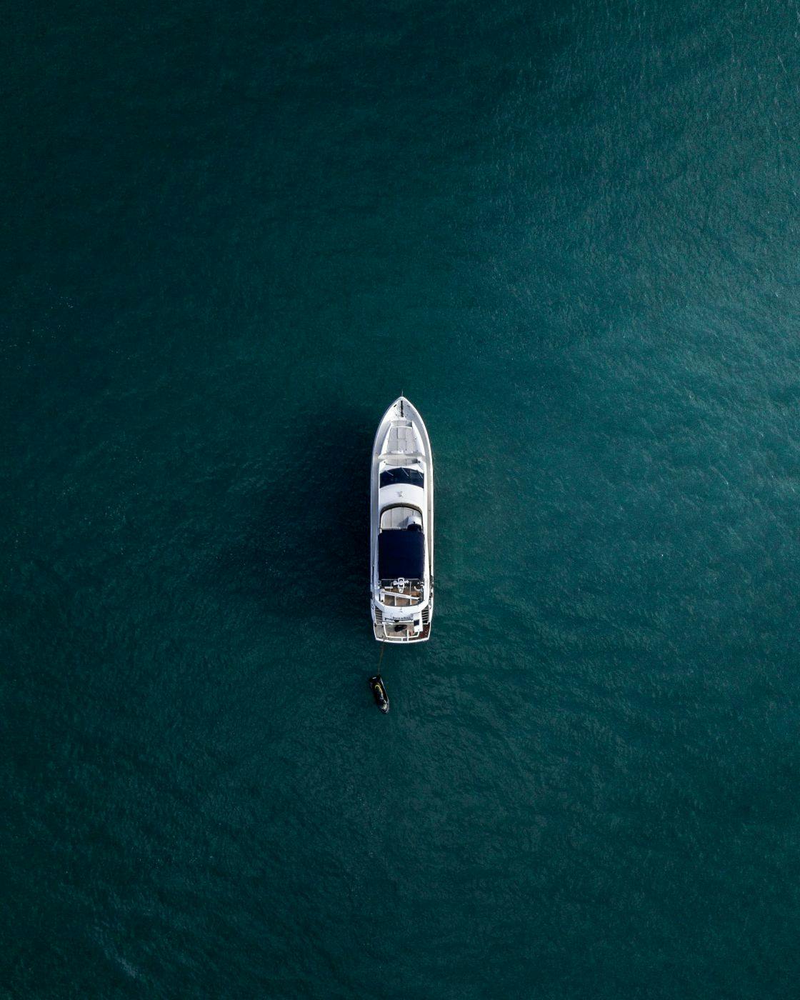 Arial shot of a white yacht on calm blue water