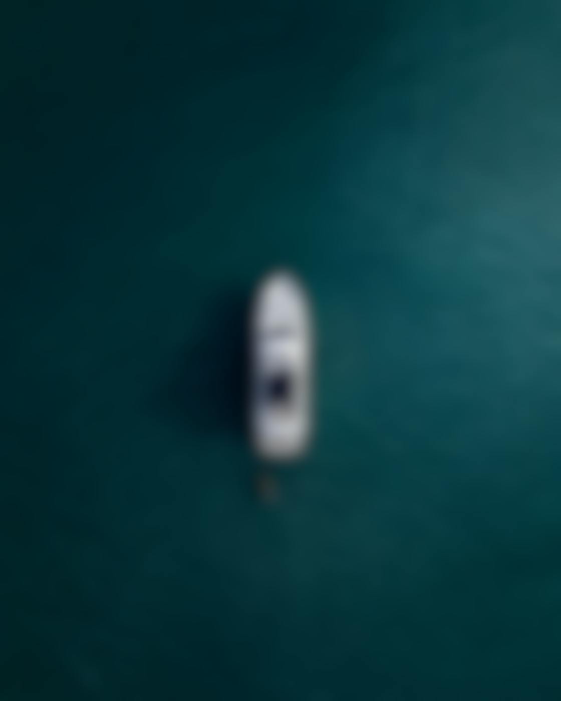 Arial shot of a white yacht on calm blue water