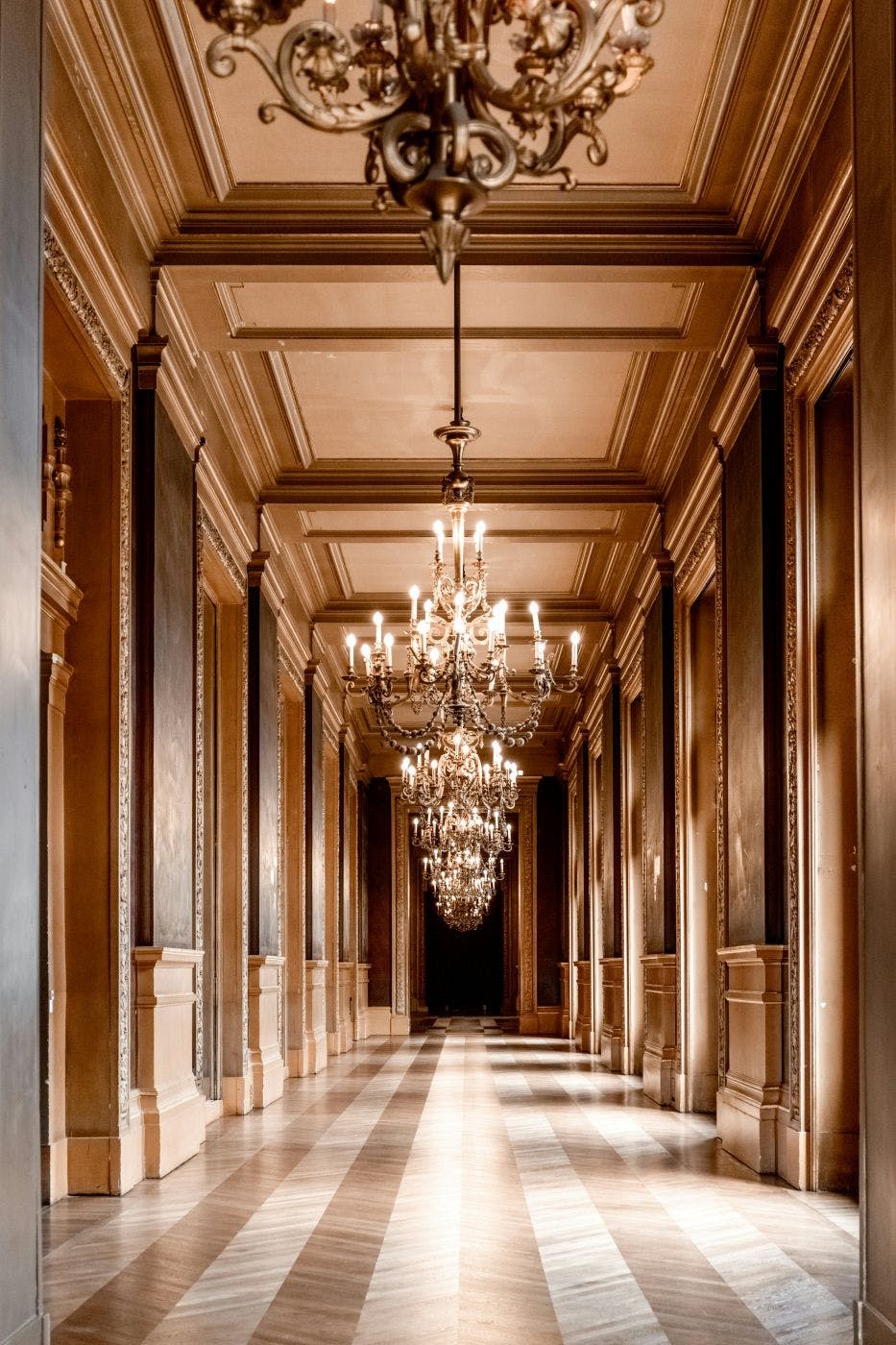 The chandeliered hallway of a luxury hotel