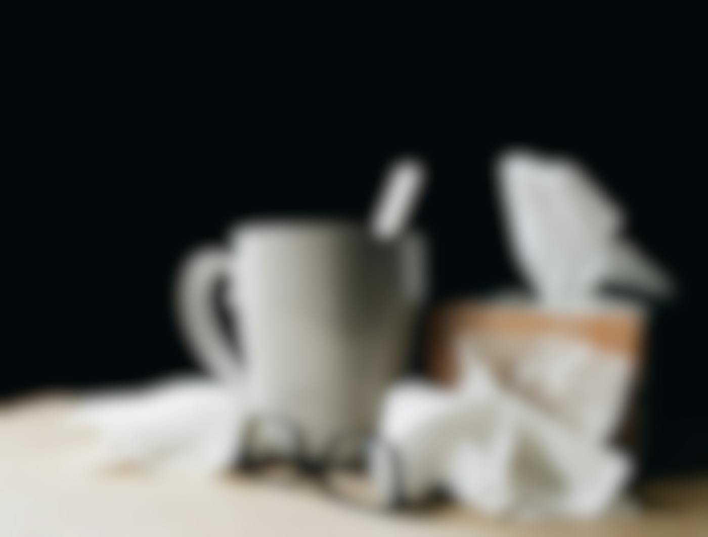 A coffee cup, pair of glasses and a box of facial tissues