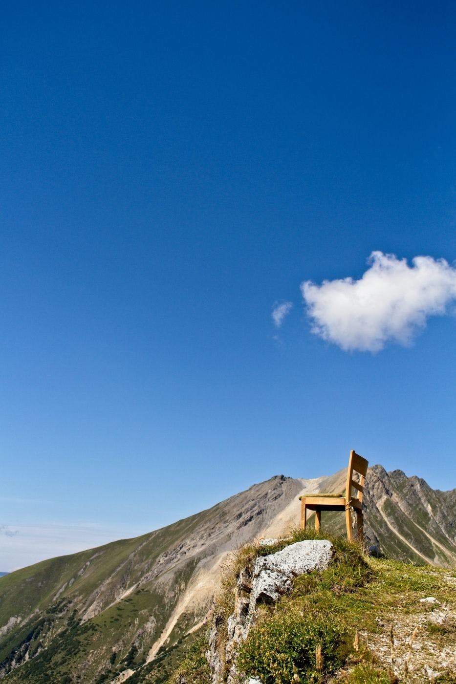 A single wooden chair on the top of a hill