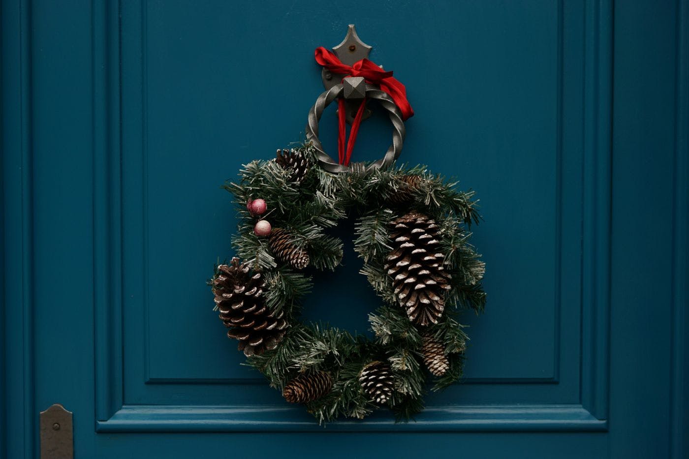 A green wreath on a blue door