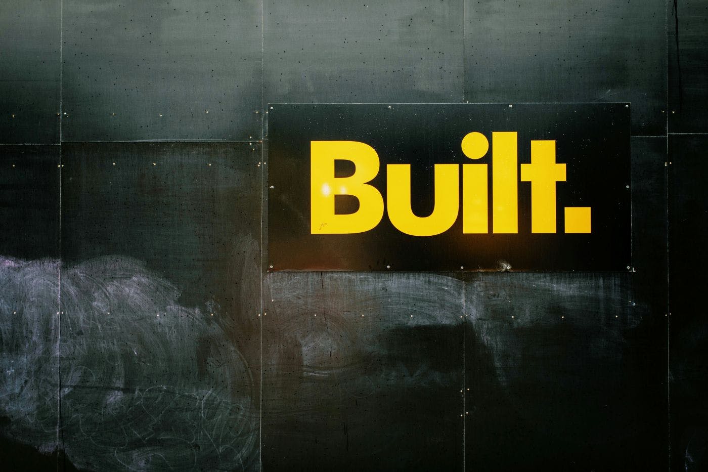 A black wall with the word Built in yellow letters