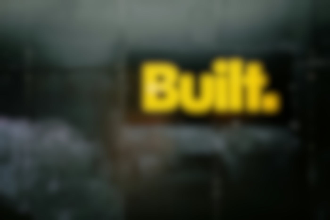 A black wall with the word Built in yellow letters